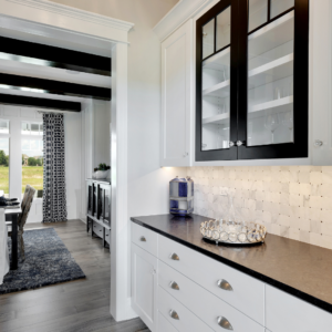 butler's pantry with white cabinets and black bench top