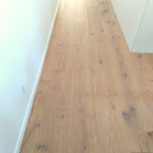 light timber flooring running into a hallway with white walls