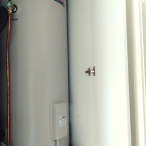 hot water system in above floor cabinet with cabinet door open