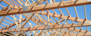 exposed roof trusses set against a blue sky
