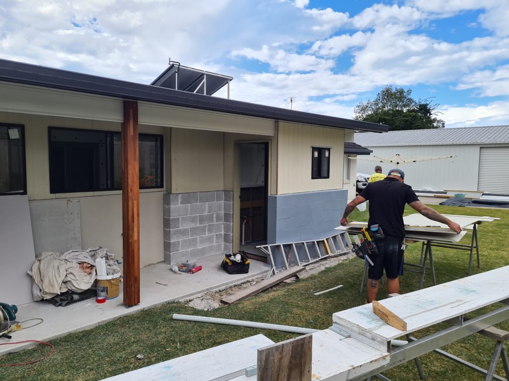 carpenter working in front of extension featuring cladding