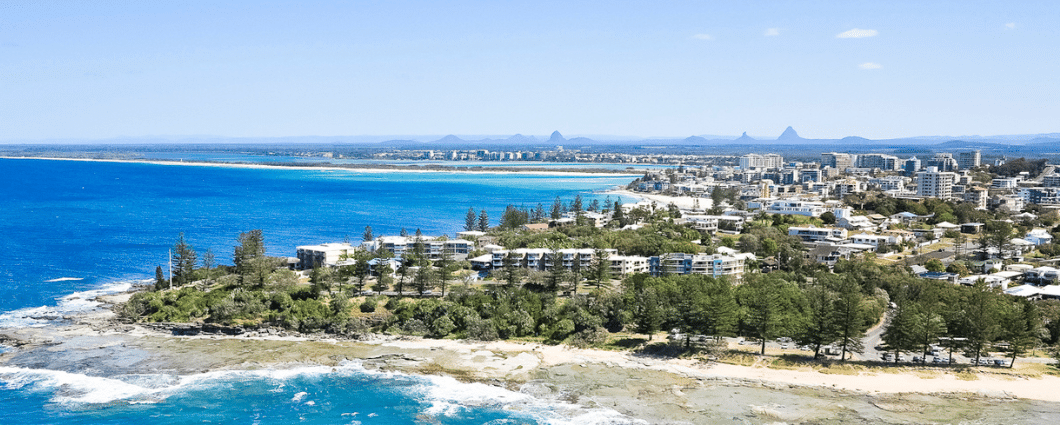 sunshine coast coastline with views of ocean, beach and units. Glass House Mountains can be seen in the background